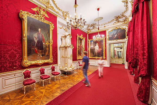 People walk through the Red Salon at Schönbrunn Palace