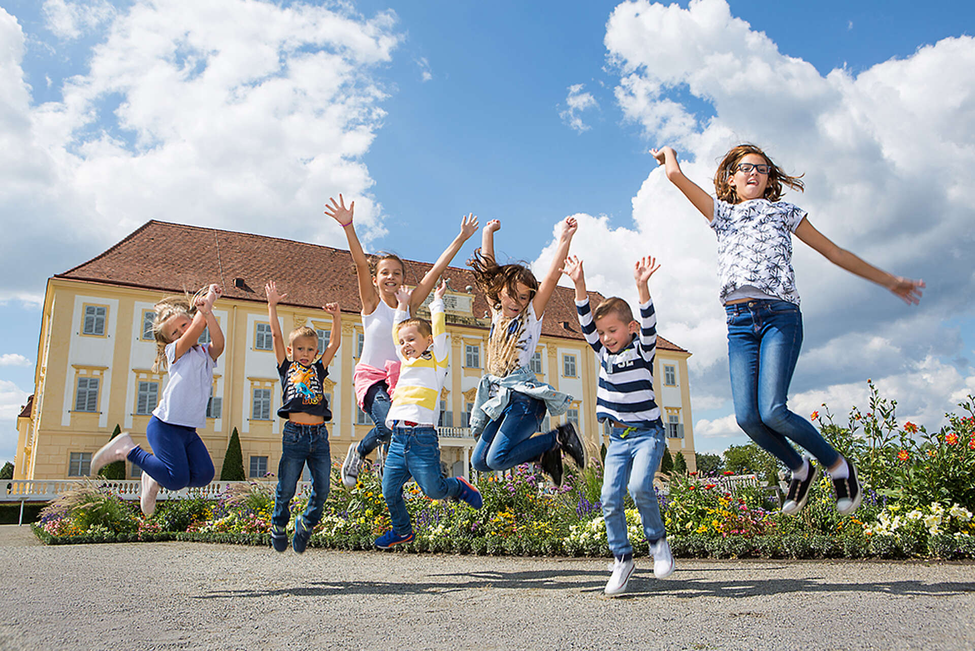 Kinder springen in die Höhe vor Schloss Hof