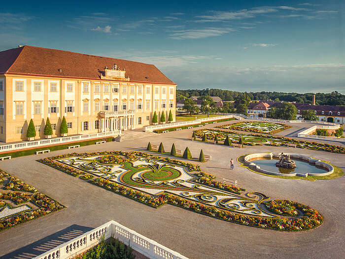 Blick auf Schloss Hof und eine Terrasse mit bunten Blumenbeeten